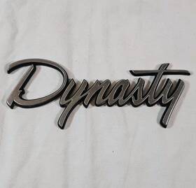 4454248 Dodge 1988-1993 Inch Dynasty Plastic Chrome Emblem - As Removed