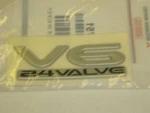 Genuine Mitsubishi Emblem Badge Nameplate " V6-24VALVE Eclipse New 03-05. Fixed Price $28.00.