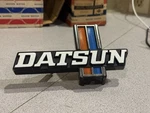 Nos 1977-1979 Nissan Datsun 620 J15 Front Grille Emblem 62394-B9500. Fixed Price $145.00.