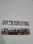 Oem B25D 51 710 Mazda Nameplate 720 Trunk Set (fits 1999-2003 Protege). Fixed Price $10.00.