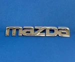 2000 2002 Mazda Silver Trunk Lid Emblem Never Mounted W Pins 662A-51711. Fixed Price $8.00.