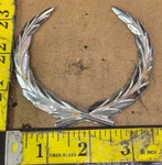Cadillac Circa '80S-'90S Wreath Trunk Emblem Like 20737651 Part No. 5770). Fixed Price $15.00.