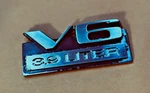1987-90 Dodge Dakota V6 3.9 Liter Emblem 4357096 2 3/4" Wide. Fixed Price $12.00.