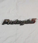2002-2003 Mazda "PROTEGE5" Plastic Trunk Emblem Removed P/n BN5W-51-720. Fixed Price $7.99.